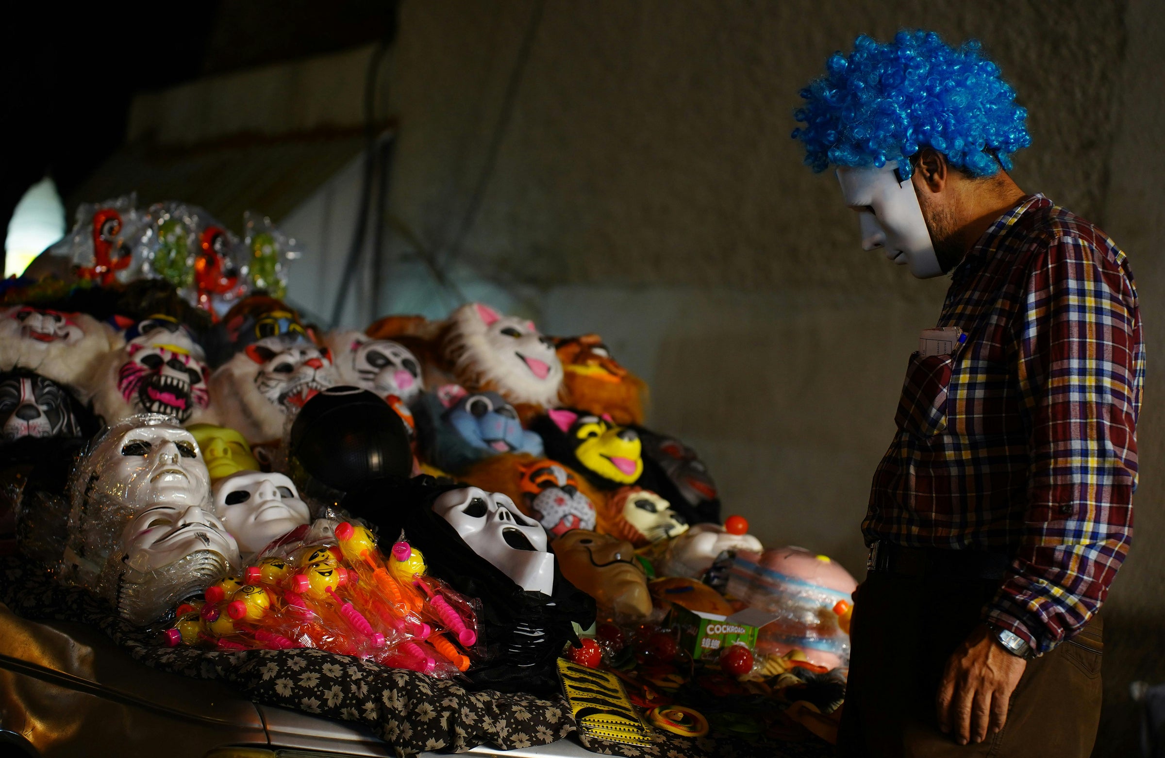 animal masks and toys displayed on a table under dim lighting.